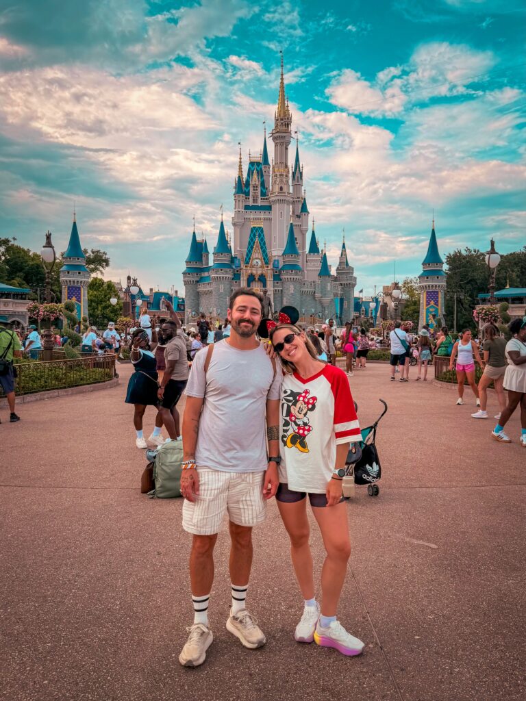 Ale e Duda em frente ao Castelo da Cinderela durante viagem segurada com a Assist 365.