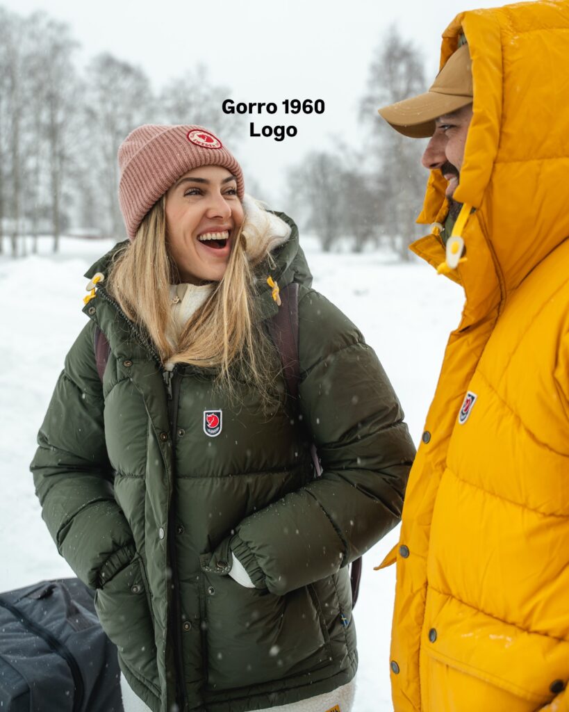 Ale e Duda usando jaquetas Fjällräven durante uma viagem na neve, experiência que embasa as recomendações sobre o cupom Fjällräven GET10.