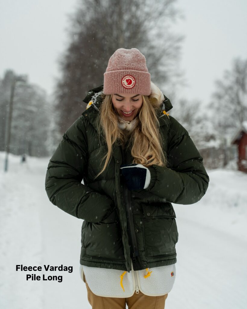 Duda usando uma jaqueta Fjällräven durante uma viagem em região de neve.