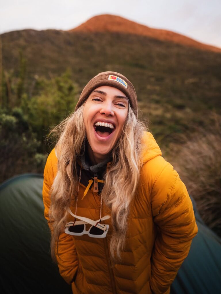 Duda usando jaqueta Fjällräven durante uma trilha em ambiente de montanha, mostrando o uso real da marca em viagens outdoor.