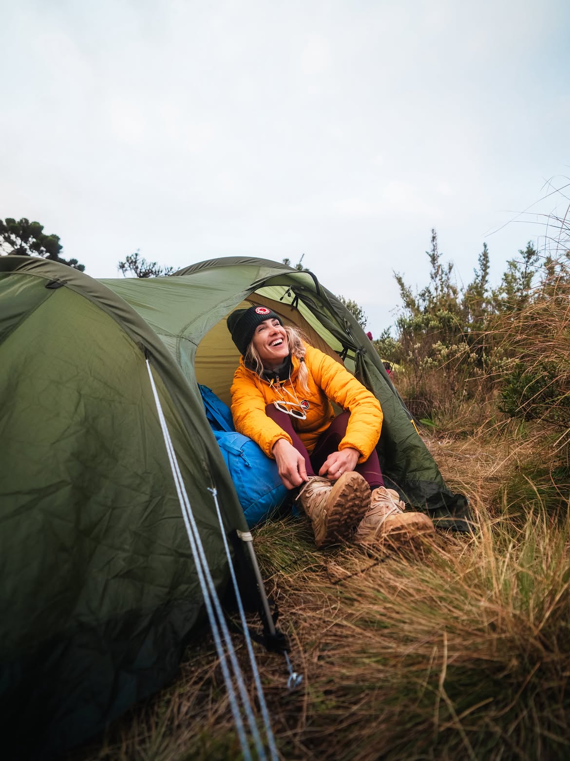 Duda utilizando roupas Fjällräven durante um acampamento, em uma experiência real de trekking e viagens de aventura.
